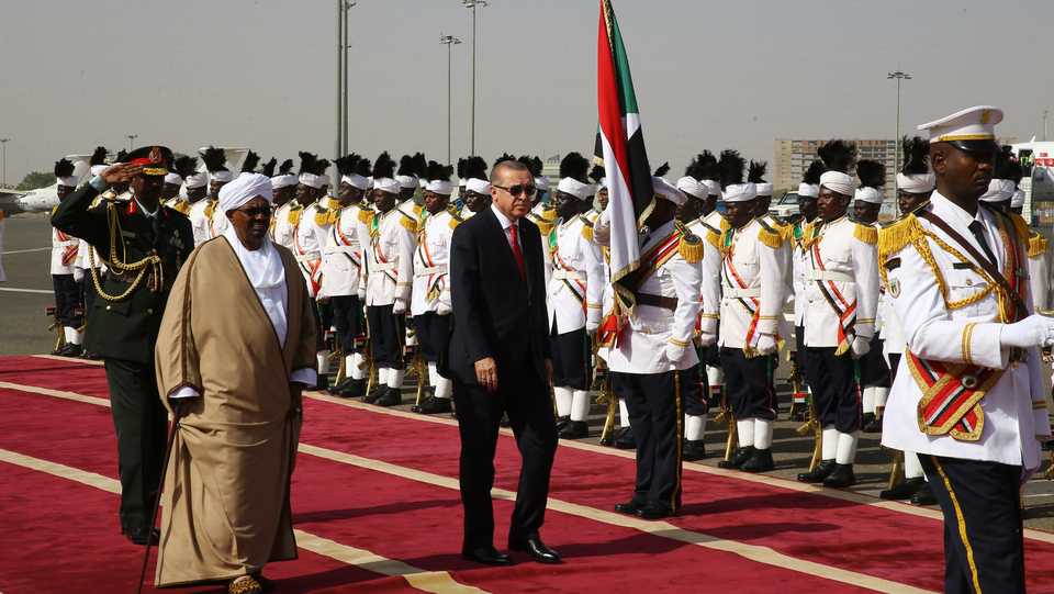 Turkish President Recep Tayyip Erdogan and Sudanese President Omar Al Bashir walk past honour guards during an official welcoming ceremony at Khartoum International Airport in the Sudanese capital on December 24, 2017.