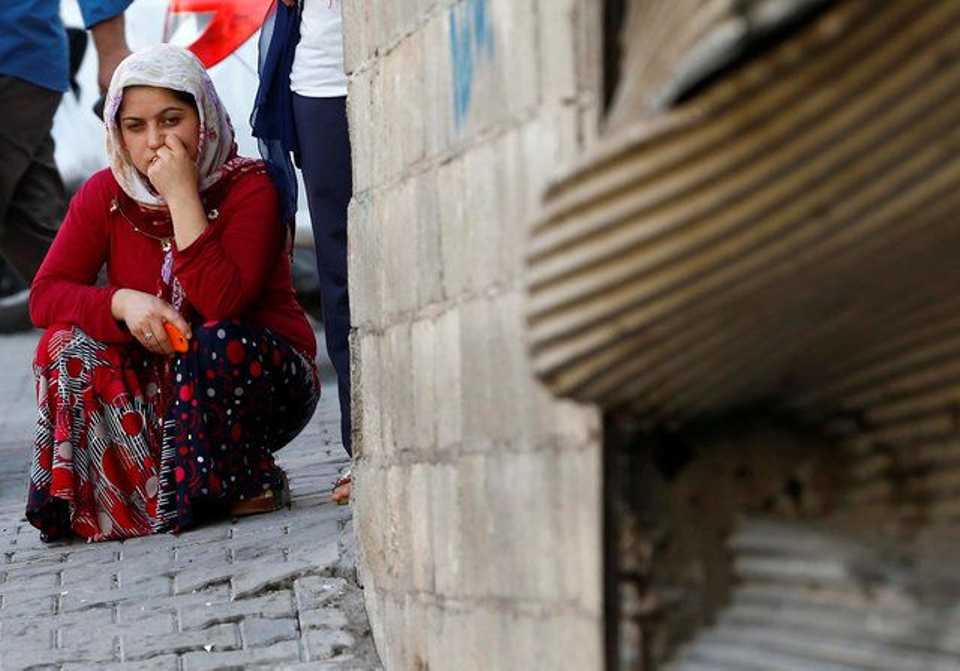 A woman pauses as she sits near the scene of an explosion where a suspected suicide bomber targeted a wedding celebration in the Turkish city of Gaziantep, Turkey, August 21, 2016. 