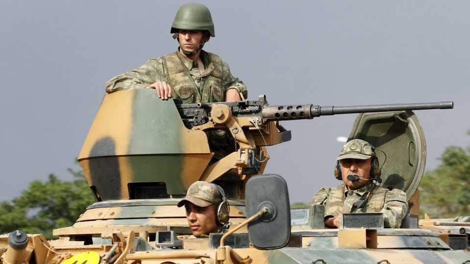 File photo shows Turkish soldiers on an armored personnel carrier as part of a Turkish military convoy.