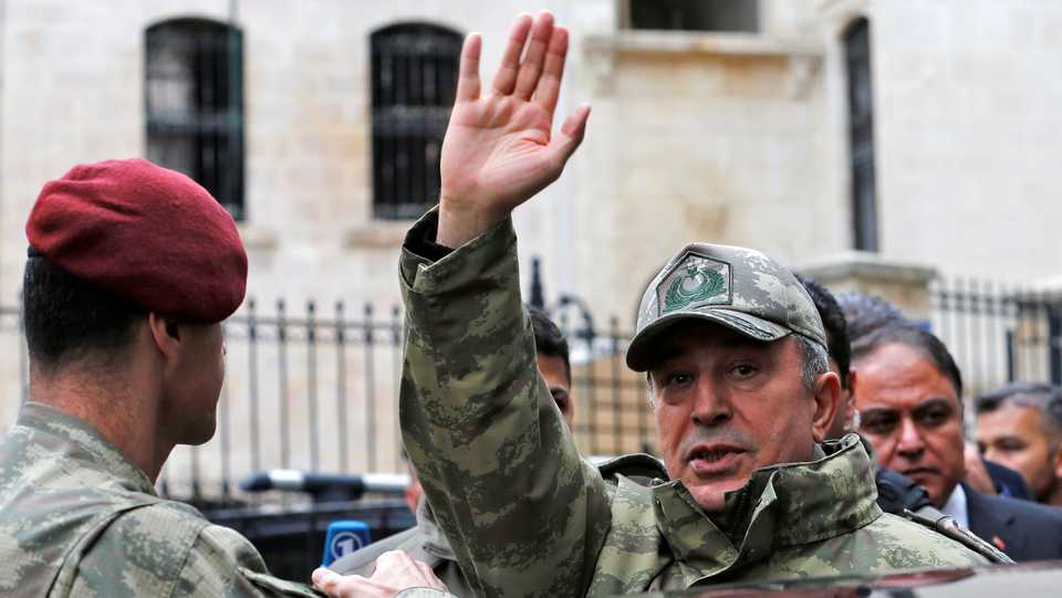 Turkey's Chief of the General Staff Hulusi Akar greets residents as he visits a neighbourhood after a building was hit by rockets fired from Syria's Afrin region in the border town of Kilis,