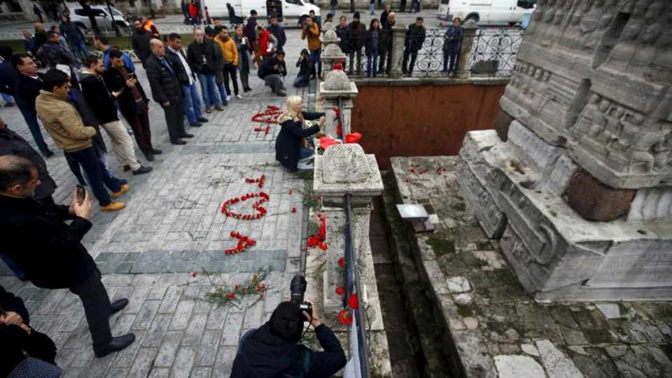 In this 2016 file picture a woman places flowers at the site of a suicide bomb attack at Sultanahmet square in Istanbul, Turkey.