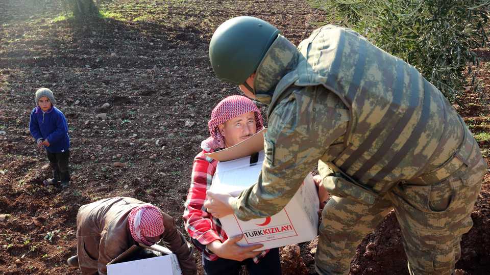 A Turkish soldiers deliver food aid to Syrians, who live in Sorke village of northern Afrin during the Operation Olive Branch in northern Syria on February 2, 2018.