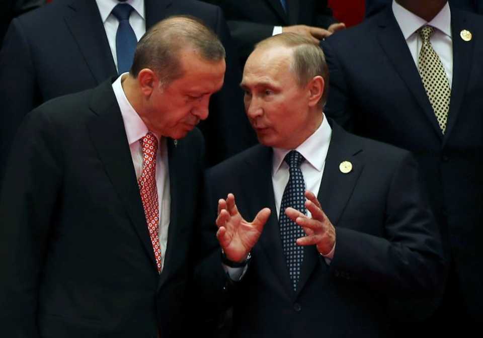 Russian President Vladimir Putin talks with Turkey's President Erdogan as they pose for a group picture during the G20 Summit in Hangzhou, China.