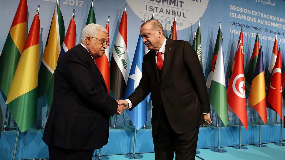 Turkey's President Recep Tayyip Erdogan, right, shakes hands with Palestinian President Mahmoud Abbas, left, following the closing news conference after the Organisation of Islamic Cooperation's Extraordinary Summit in Istanbul, December 13, 2017.