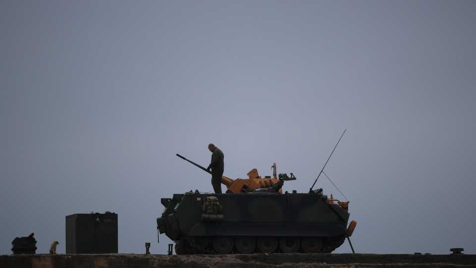 A Turkish soldier stands on an armoured vehicle in a village near the Turkish-Syrian border in Hatay province, Turkey, February 25, 2018.