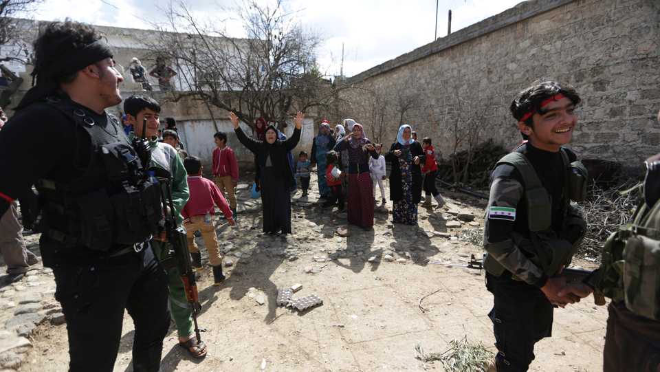 Turkish-backed Free Syrian Army fighters are seen with villagers in eastern Afrin, Syria on March 9, 2018.