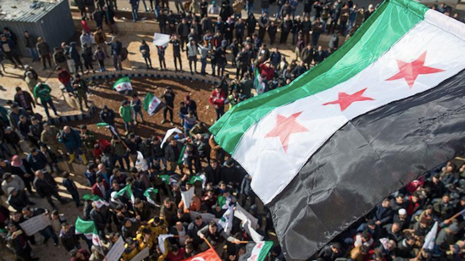 Protesters carrying Free Syrian Army and Turkish flags block a road between Azaz city and Sijo town in Aleppo province of Syria on March 24, 2018.