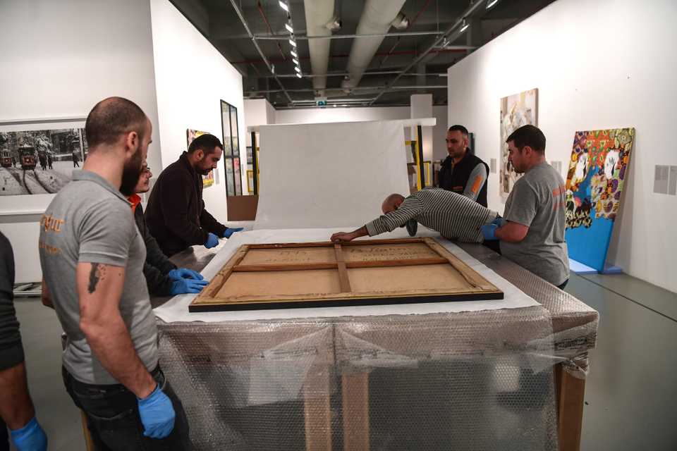 Workers pack a painting at Istanbul Modern museum in Istanbul. The museum, after closing its doors on March 18, will reopen in a historic Istanbul mansion in the central Beyoglu district in May, March 23, 2018.