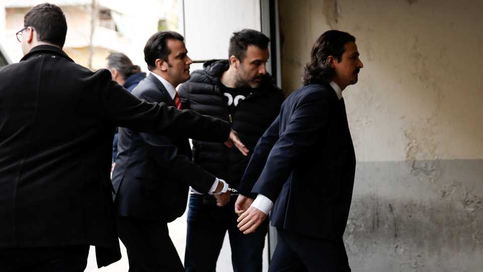 Two of the eight former Turkish soldiers, who fled to Greece and requested political asylum after a failed military coup in Turkey, are escorted by police officers as they arrive at the appeals court in Athens, Greece. March 16, 2018.