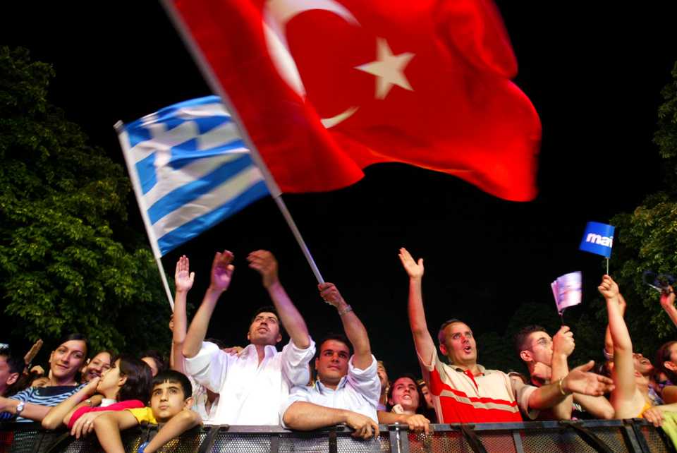 Turks and Greeks have lived peacefully for centuries, seen in this July 7, 2004 file photo as fans wave their national flags in Istanbul, Turkey, during a pop concert.