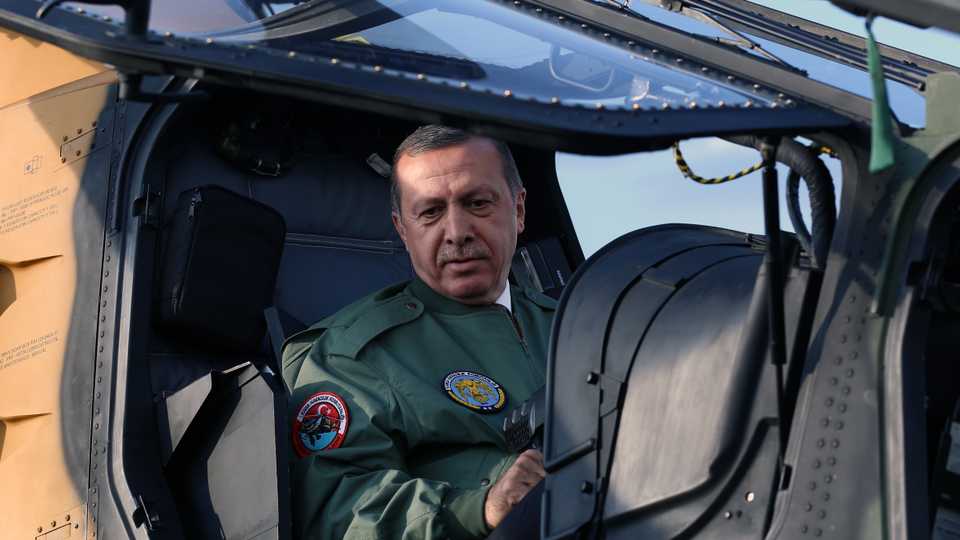 On June 10, 2014 photo, Turkish Prime Minister Recep Tayyip Erdogan sits in the pilot's seat during a presentation for the Turkish-made military helicopter, T129 ATAK, outside Ankara, Turkey.