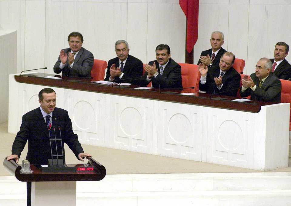 Erdogan is sworn in at the Turkish parliament after he was elected from Siirt province in 2003, Abdullah Gul is seen in the background (centre) while clapping.