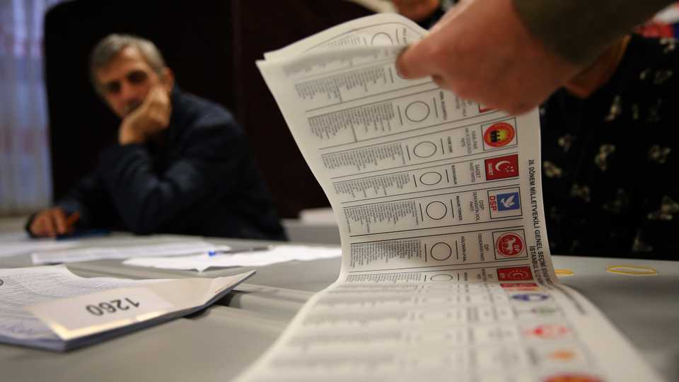 A Turkish election official counts ballots shortly after the polling stations closed at the end of the election day, in Istanbul, Sunday, November 1, 2015.