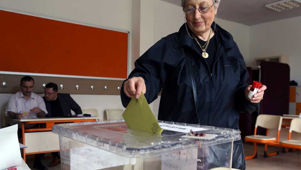 In this June 7, 2015 file photo, a Turkish woman casts her vote at a polling station in a primary school in Ankara, Turkey.