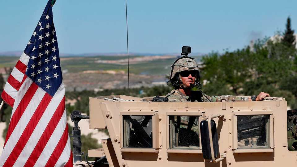 In this April 4, 2018 file photo, a US soldier sits on his armored vehicle in Manbij, northern Syria.