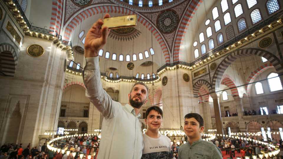 Muslims take a selfie after performing the Eid al Fitr prayer at Suleymaniye Mosque in Istanbul, Turkey on June 15, 2018.
