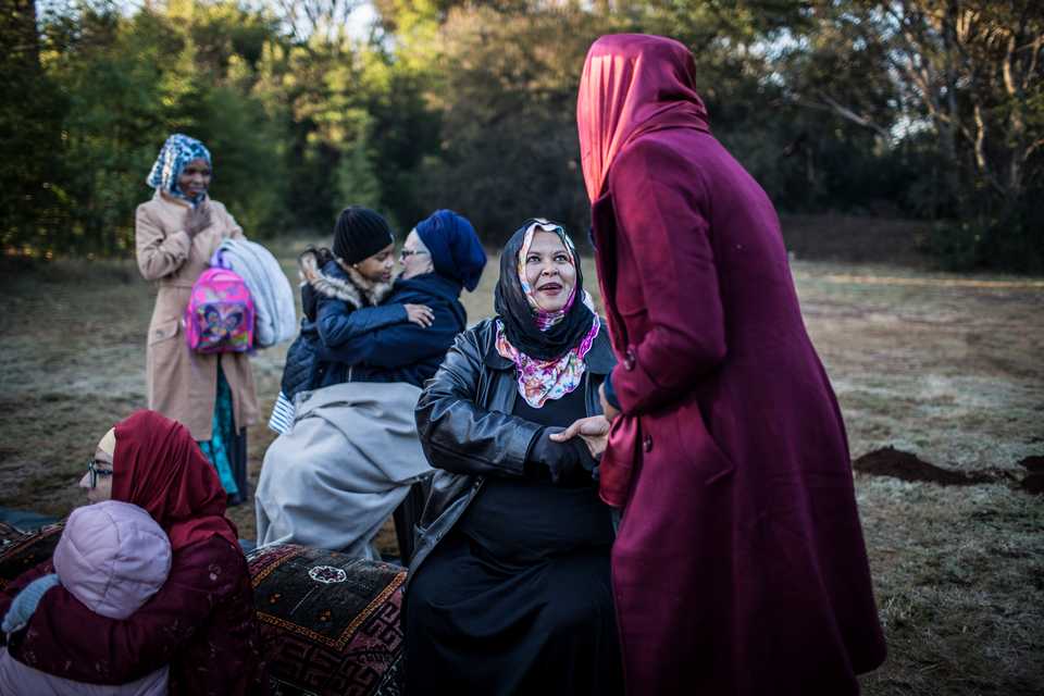 Women greet each other before the Eid-Gah, the prayer on the morning of the Eid al Fitr celebration which marks the end of the holy month of Ramadan on June 15, 2018 at the Rasooli Masjid in Pretoria, South Africa.