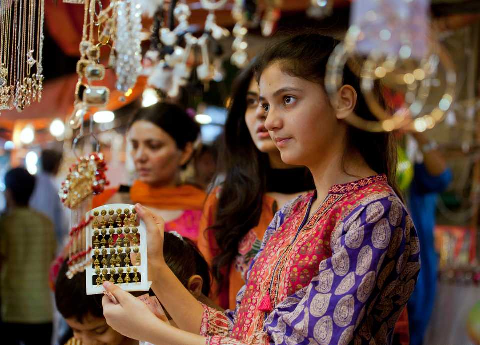A young girl chooses jewelry at a market in preparation for the upcoming Eid al Fitr celebrations to mark the end of the Islamic fasting month of Ramadan, in Islamabad, Pakistan, Tuesday, June 12, 2018.