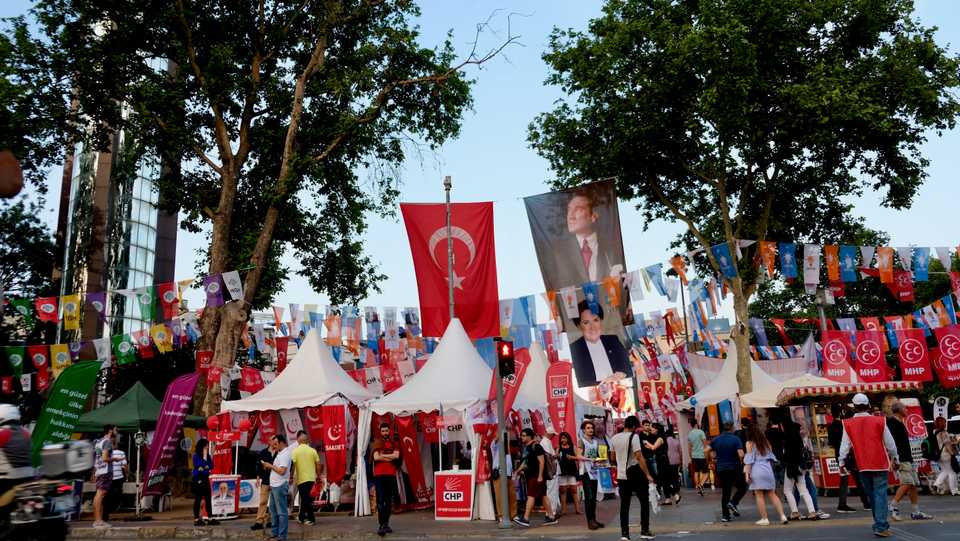 People walk under election posters for Turkey's political parties and their leaders ahead of the June 24 elections, Besiktas, Istanbul, June 7, 2018.