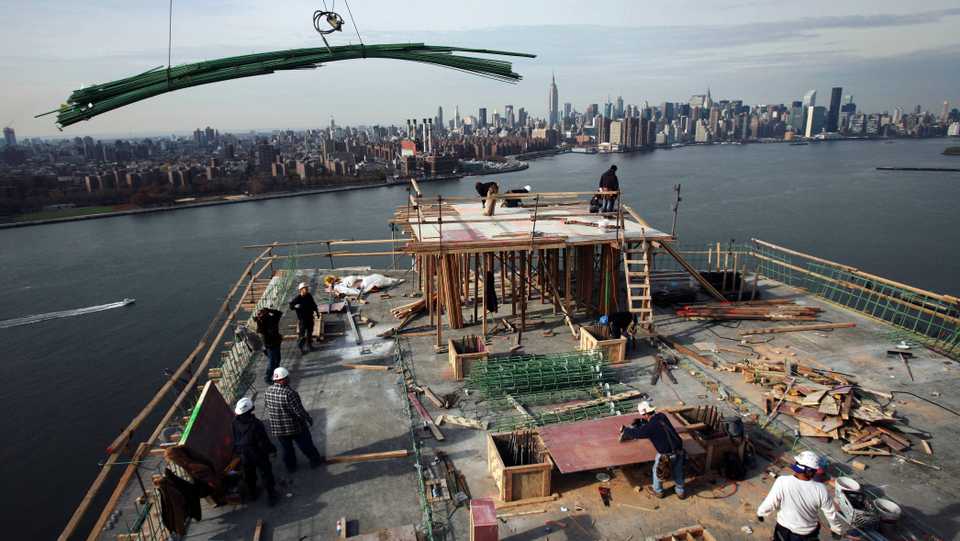 In this file photo from November 2008, steel bars are lowered by crane onto the roof of a condo project in the Williamsburg section of New York.
