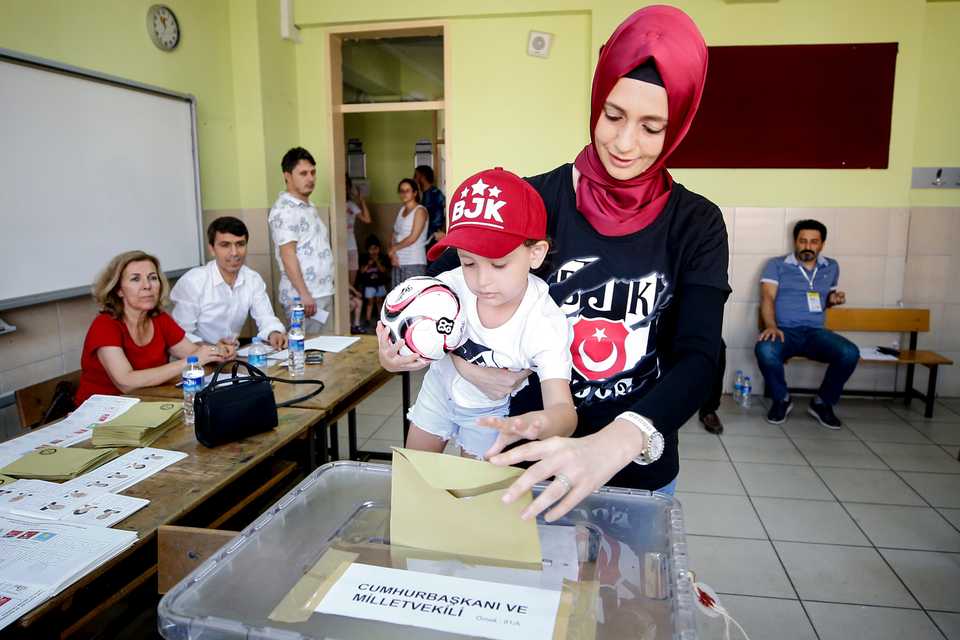 A voter and her son, dressed in Besiktas gear votes in the resort city of Antalya.
