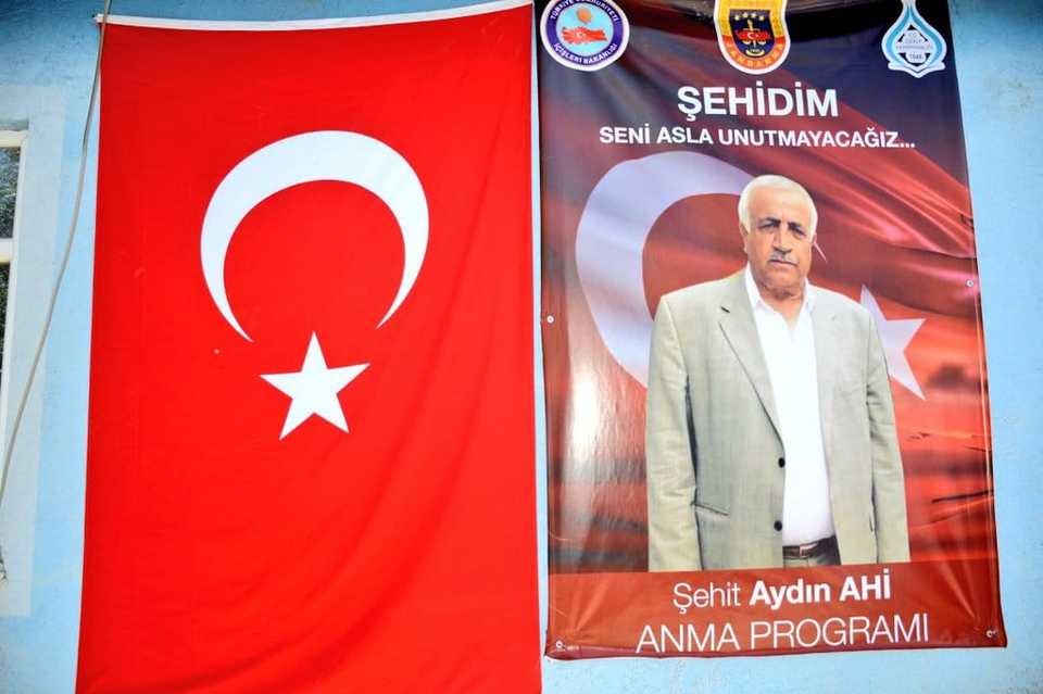 A Turkish flag and a poster of Aydin Ahi on a wall during a ceremony commemorating his killing in Van, Turkey on July 1​, 2018.