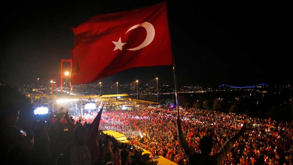 In this July 21, 2016 file photo, A Turkish flag is seen as Turkish people protest against a coup attempt on the road leading to Istanbul's iconic Bosphorus Bridge, background left, in Istanbul, Turkey.