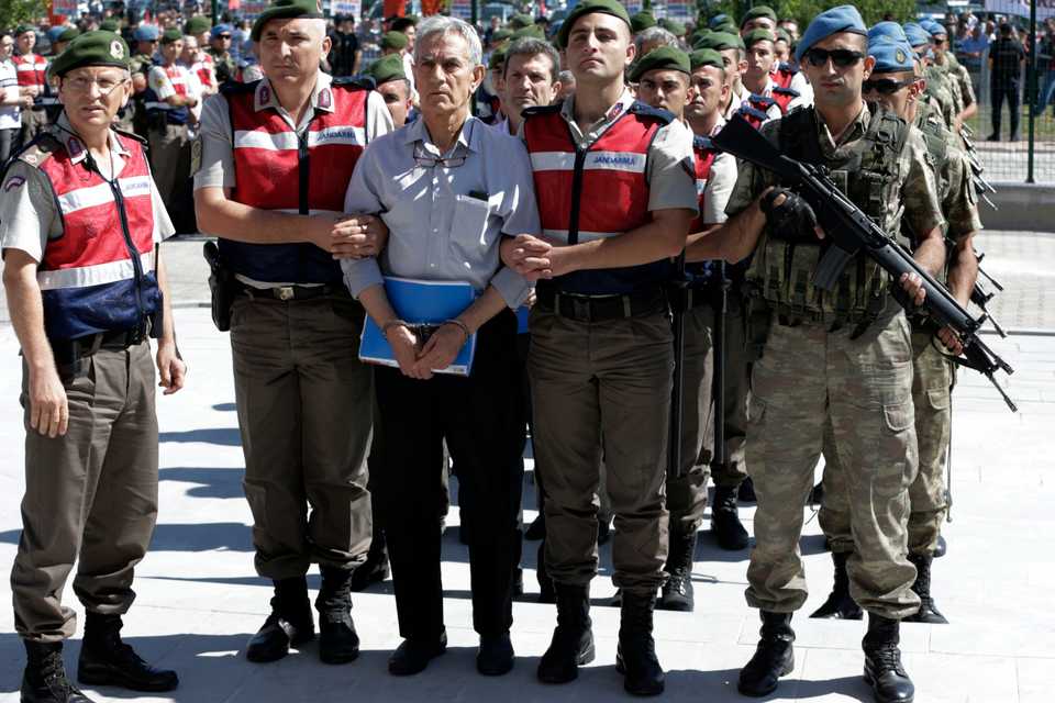 In this August 1, 2017 file photo, Turkish police and members of the special forces escort former Air Force commander Akin Ozturk and other suspects of the failed coup, outside the courthouse at the start of a trial, in Ankara, Turkey.