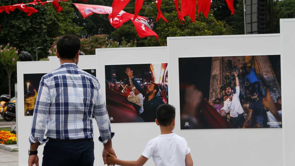 In this July 14, 2017 file photo, people visit an outdoor exhibition in Istanbul featuring photographs of the coup attempt.