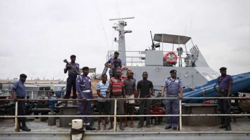 Naval police stand guard as suspected pirates are paraded aboard a naval ship after their arrest by the Nigerian Navy at a defence jetty in Lagos on August 20, 2013.
