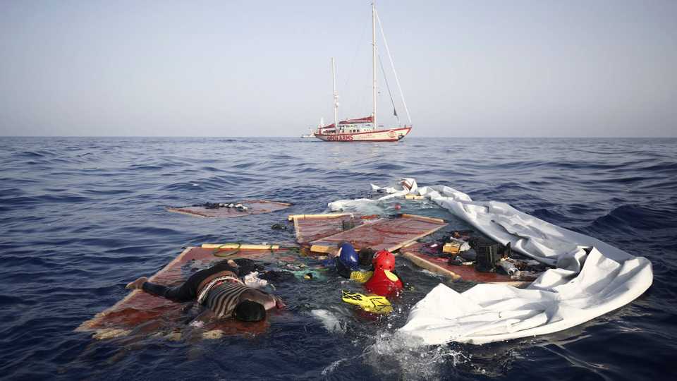Rescue workers from the Proactiva Open Arms Spanish NGO retrieve the bodies of an adult and a child amid the drifting remains of a destroyed refugee boat off the Libyan coast. A migrant rescue aid group accused Libya's coast guard of abandoning three people in the Mediterranean Sea, including an adult woman and a toddler who died, after intercepting some 160 Europe-bound migrants on July 16 near the shores of the northern African country. July 17, 2018.