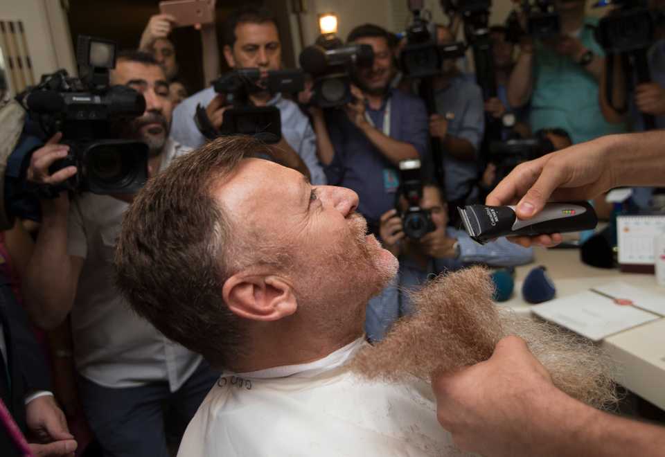 All cameras focus on his face as his beard lis cut.