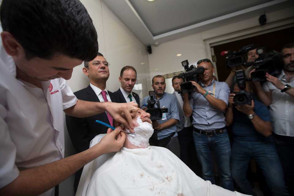 Photographers record his beard being cut off after the lifting of the state of emergency.
