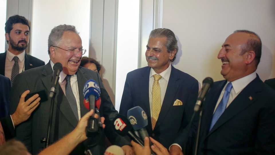 Greek Foreign Minister Nikos Kotzias, left, and Turkish Foreign Minister Mevlut Cavusoglu, right, joke as they attend the inauguration of the renovated Greek consulate in Izmir, Turkey, Tuesday, September 4, 2018.
