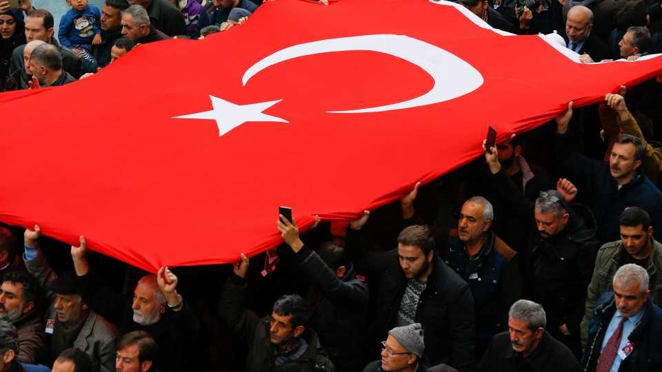 Friends and relatives of police chief Kadir Yildirim who was killed in Saturday's blasts, march with a Turkish flag during a funeral ceremony in Istanbul, Turkey, December 12, 2016. 