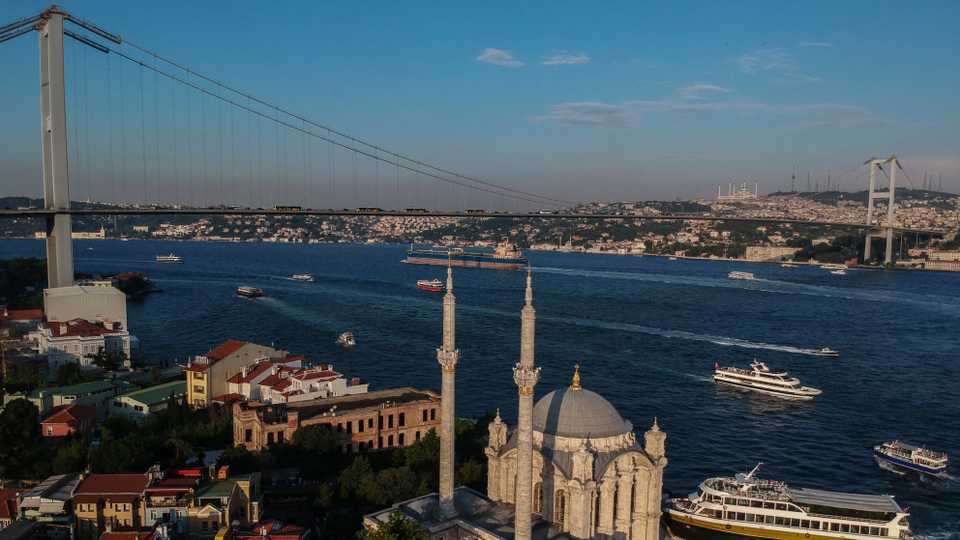 In this aerial photo, the Ottoman-era Mecidiye mosque in Ortakoy square is backdropped by the July 15th Martyrs' bridge, formerly known as Bosphorus Bridge, over the strait. June 22, 2018.