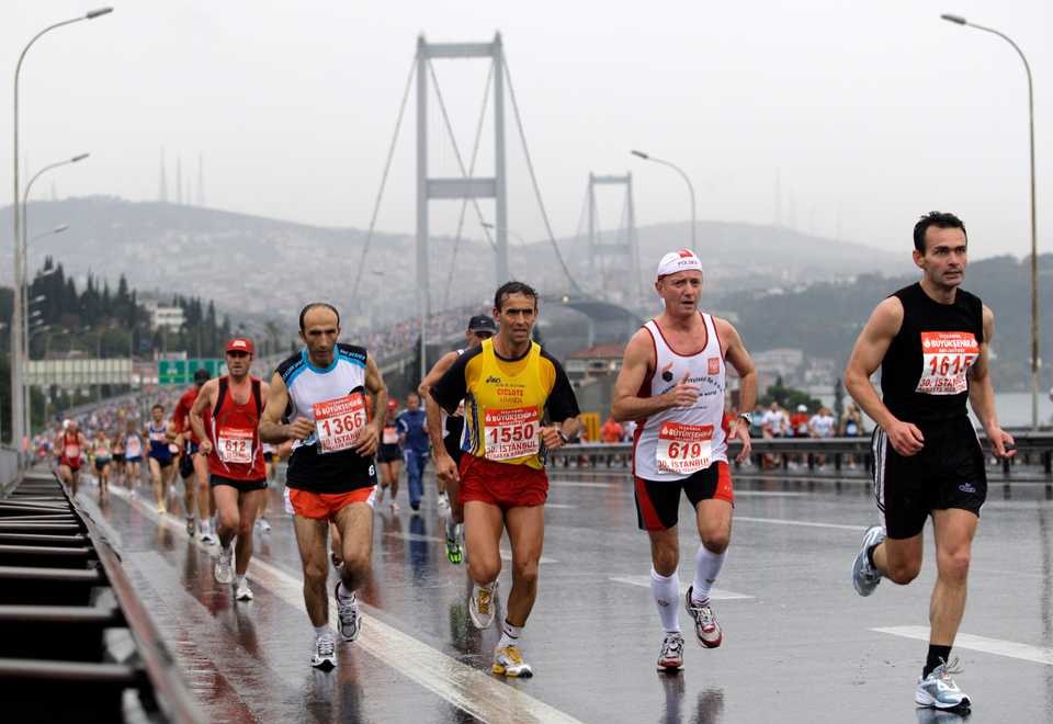 Participants run in the rain during the 30th Eurasia marathon, with the Bosphorus bridge in the background, in Istanbul, Turkey, October 26, 2008. Tens of thousands of people took part in the 30th Eurasia marathon, which started on the Asian side of Istanbul and ended on the European side.