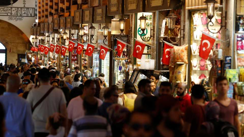 Tourists walk in a covered market and shopping in Istanbul in August 20, 2018.