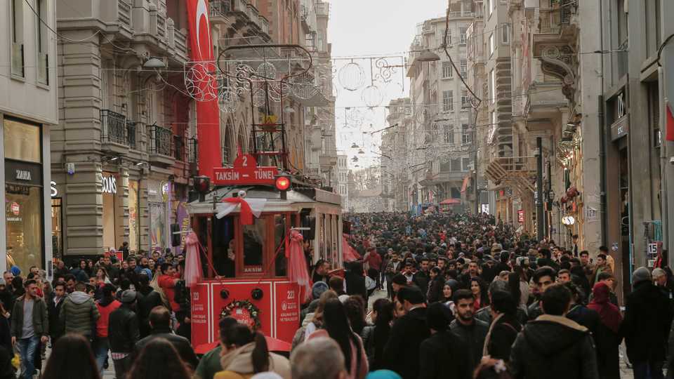 People walk along the popular shopping avenue Istiklal Street near Taksim Square in Istanbul. December 31, 2017.