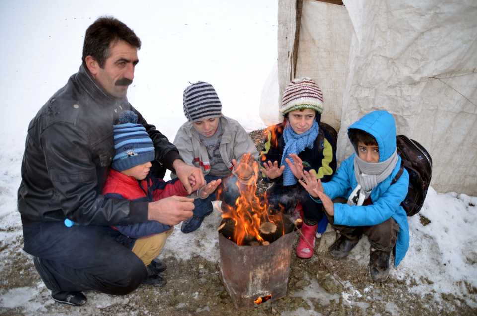 Engin and his kids take a break to get warm on their way to the school bus in the snowy weather.