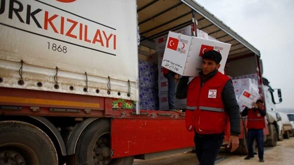 Turkish Red Crescent workers carry humanitarian aid at Kelbit camp near the Syrian-Turkish border in Idlib province, Syria on January 17, 2018.
