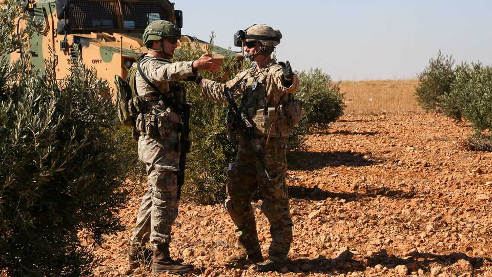US and Turkish soldiers discuss details during the first-ever combined joint patrol in Manbij, Syria, November 1, 2018.