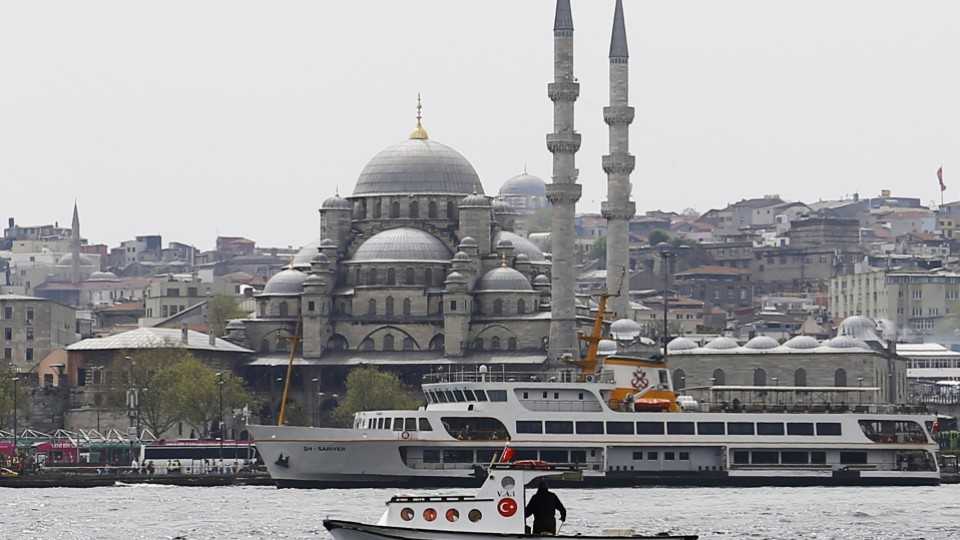 A fishing boat sails in the Golden Horn with 17th-century Ottoman era New Mosque in background in Istanbul, Turkey, April 14, 2016.