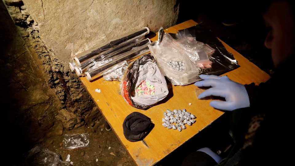 A Turkish anti-narcotics police officer counts confiscated narcotics during a drug raid in Istanbul, Turkey on January 16, 2018