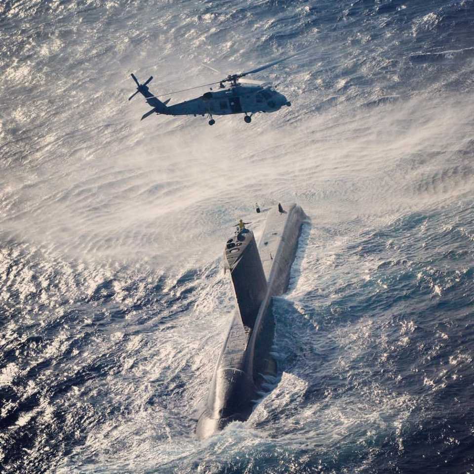 A Sikorsky SH-60 Seahawk flies over a submarine deployed in the Aegean Sea for the 'Blue Homeland 2019' military exercise offshore Mugla, Turkey on February 27, 2019.