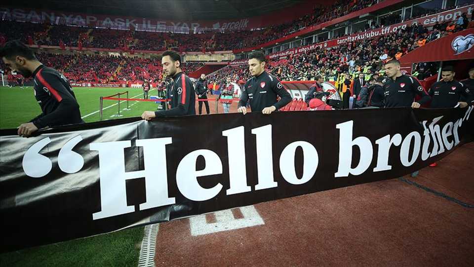 Turkish National Team coming onto the field with the #HelloBrother placard.