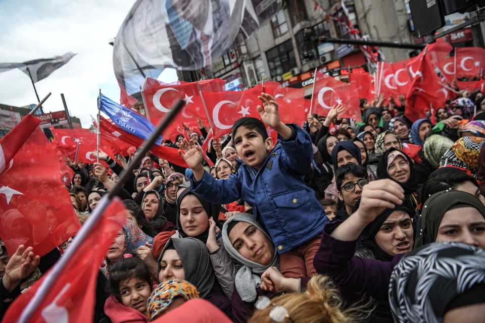 Supporters of Justice and development Party (AKP) cheer and wave Turkish national flags as the Turkish President speaks during an election rally in Istanbul. (March 29, 2019)