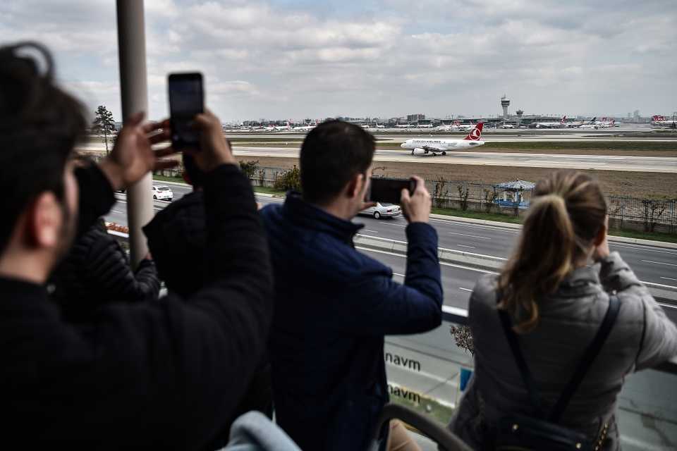 People take pictures of taking off airplanes from a terrasse of the Ataturk Airport on April 4, 2019, in Istanbul.
