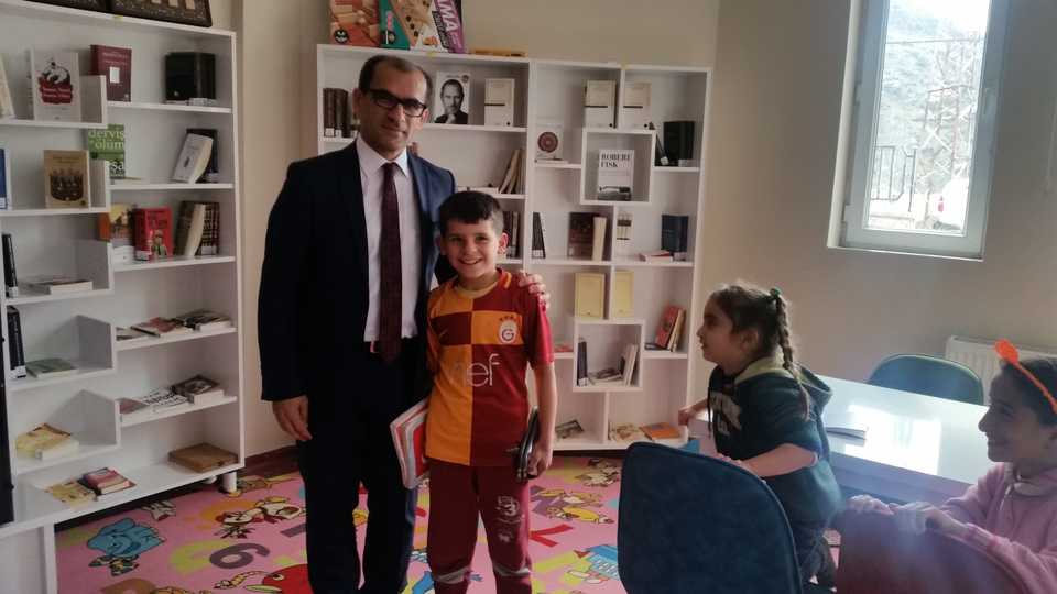 District governor Temel Ayca poses with a student from a local school at a book cafe in Cukurca. He has established classroom libraries and book cafes across Cukurca’s schools.