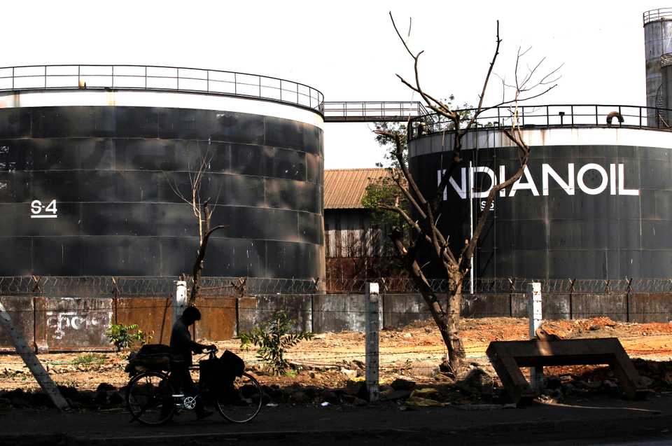 File photo. A cyclist walks past an Indian Oil company in Mumbai, India, May 7, 2012.